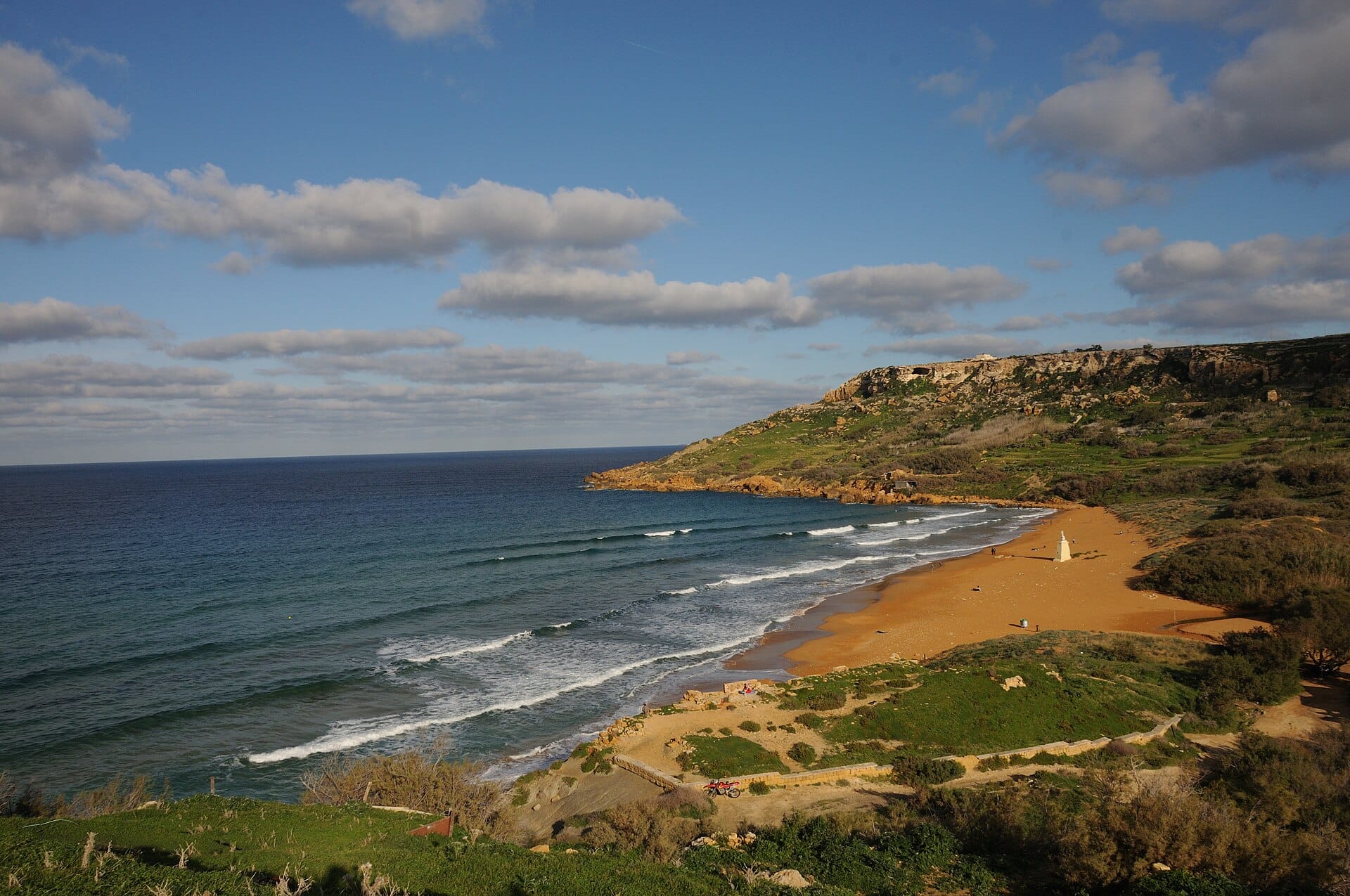 Ramla Bay on Gozo, a wide beach of red gold sand with waves rolling in