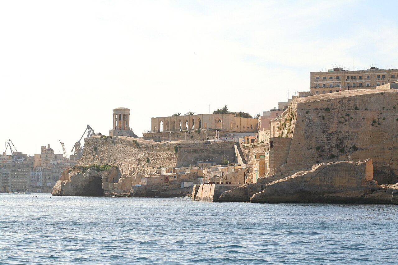 The bastions of Valletta and the Siege Bell Memorial seen from a boat entering the Grand Harbour