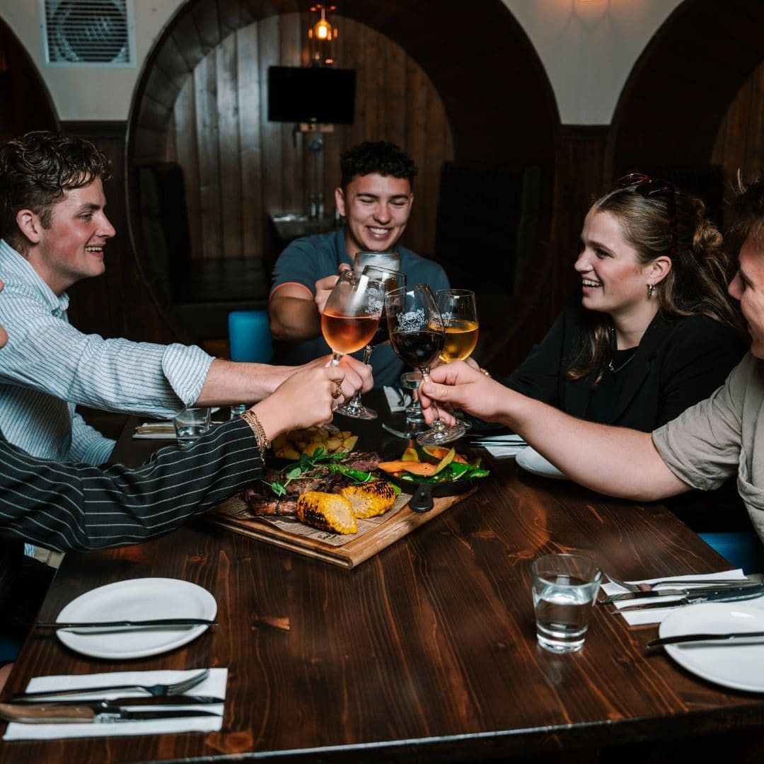 A group of friends raising glasses over a shared meal