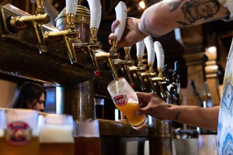 Beer being poured into a glass from brass taps at the Montekristo brewery bar