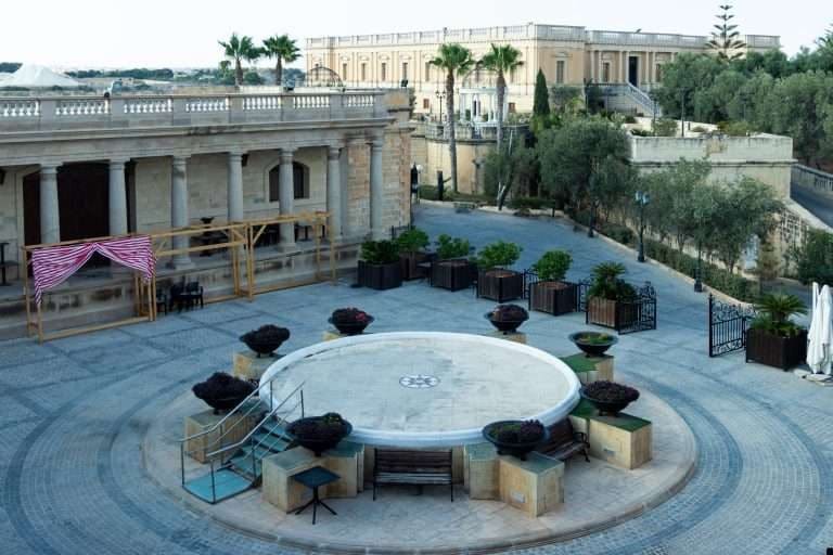 Courtyard with a round fountain surrounded by planters, seen from above