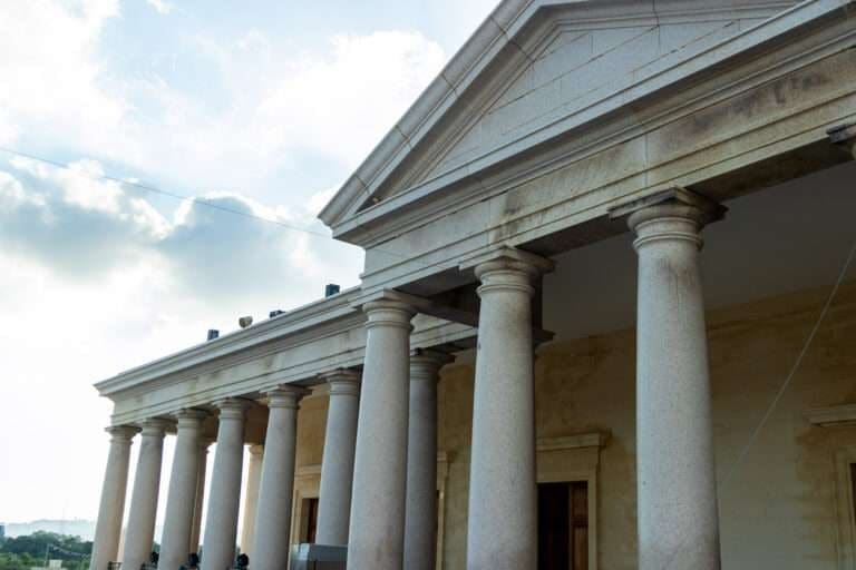 Columned portico of The New Renaissance under a blue sky
