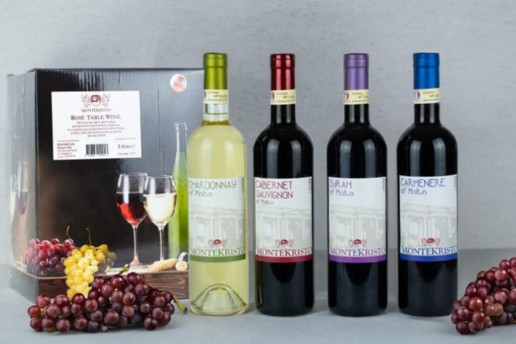 A display of Montekristo wines in front of a boxed table wine, with red and white wine glasses and grapes