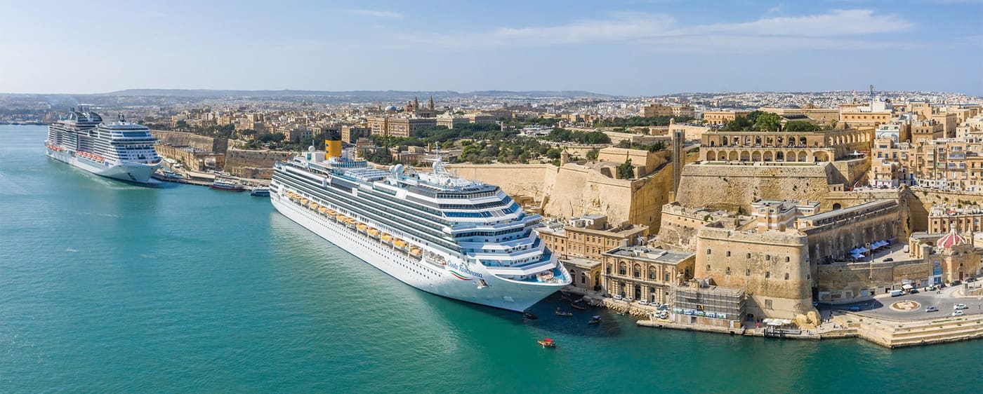 A large cruise ship berthed in the Grand Harbour beside Valletta's golden bastions
