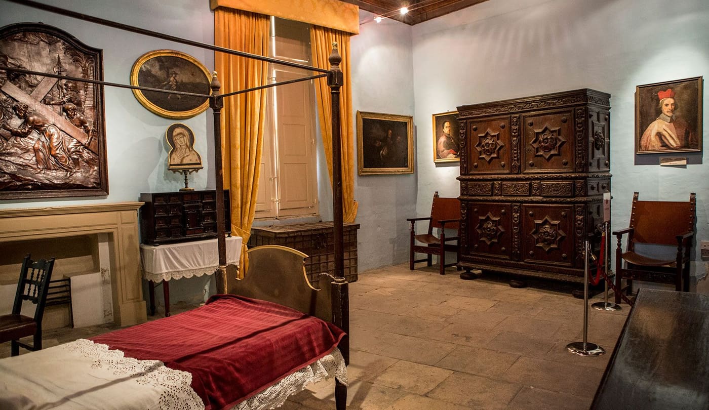 A period bedroom with antique furniture inside the Inquisitor's Palace