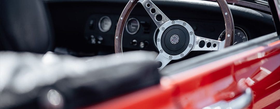 The steering wheel and dashboard of a classic MG car