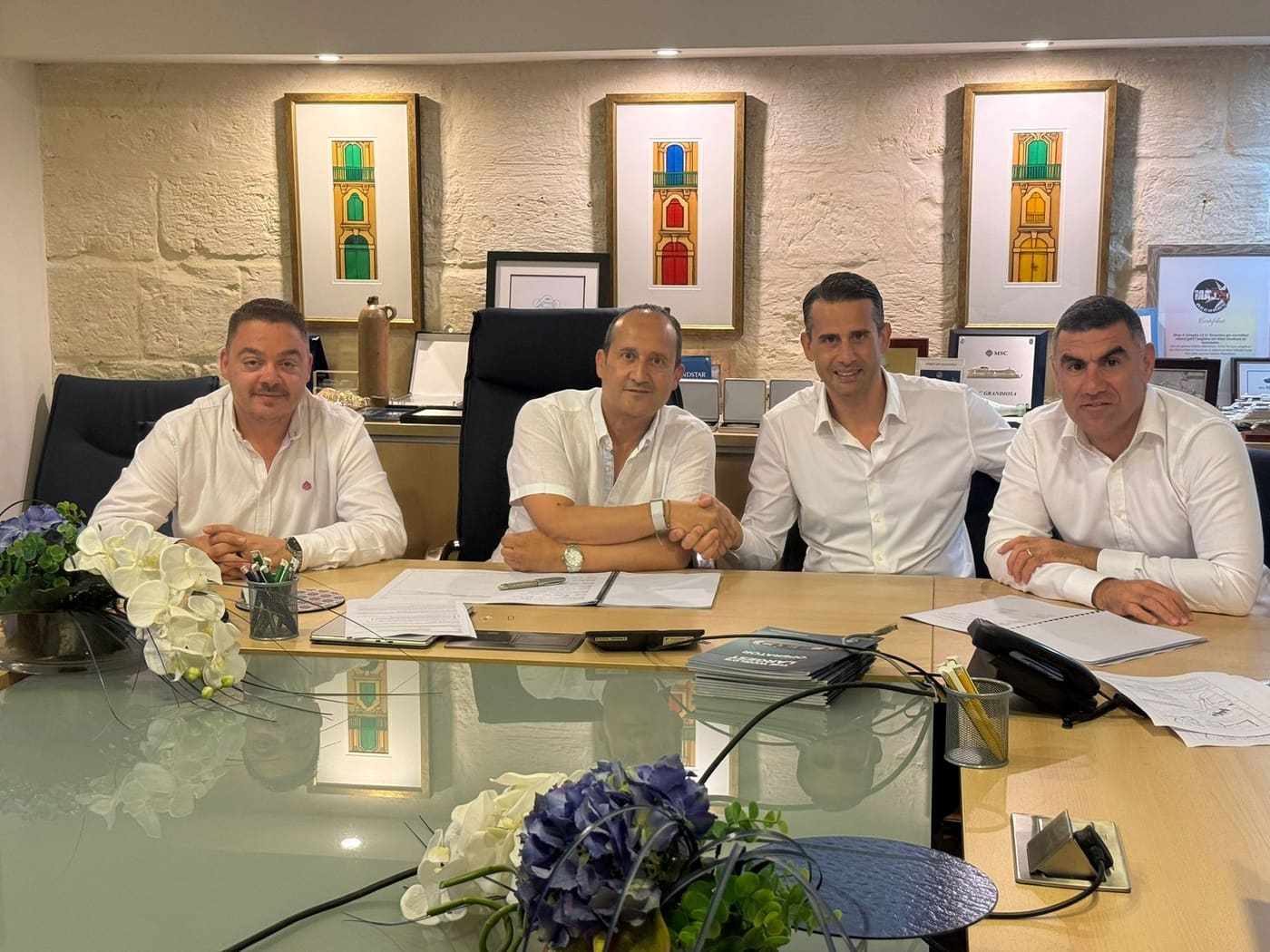 Business people signing an agreement around a table