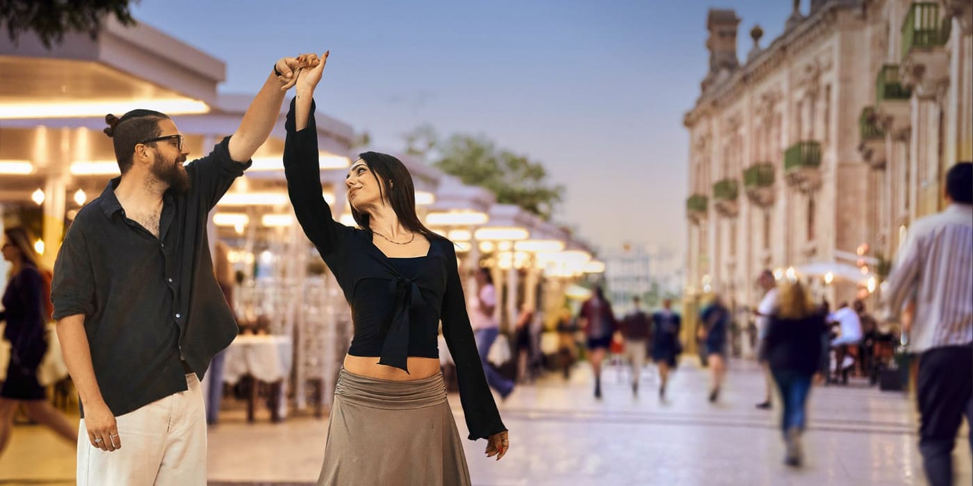 A couple dancing on a lively pedestrian street near the Valletta Waterfront at dusk